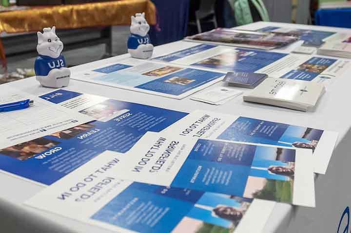 Brochures on a table with Billiken toys